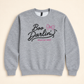 Heather gray Boo Darlin’ embroidered sweatshirt, neatly arranged on a warm ivory studio background