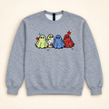 Heather gray sweatshirt with four patterned ghost appliqués, neatly arranged on a warm ivory studio background