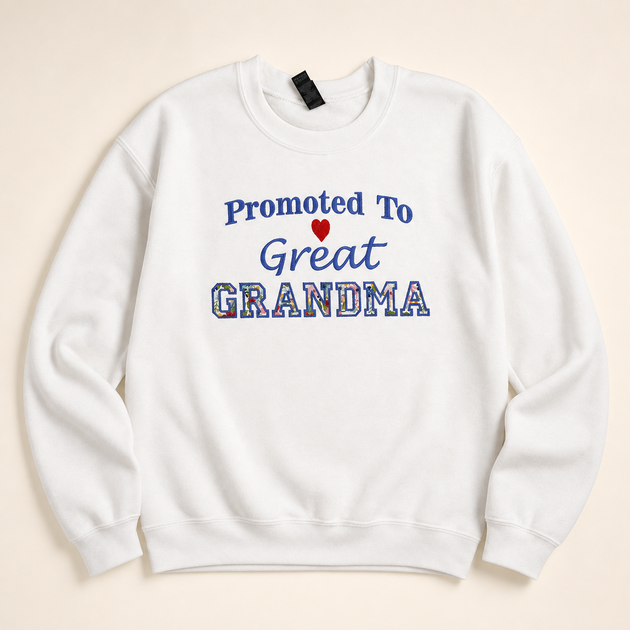 White Promoted to Great-Grandma appliqué sweatshirt on a warm ivory studio background