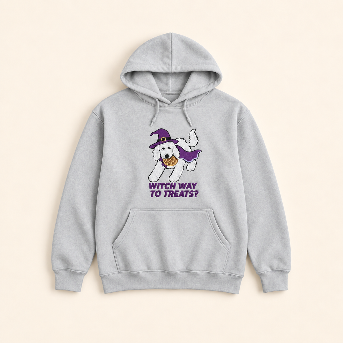 Light gray Witch Way to Treats embroidered hoodie, neatly arranged on a warm ivory studio background